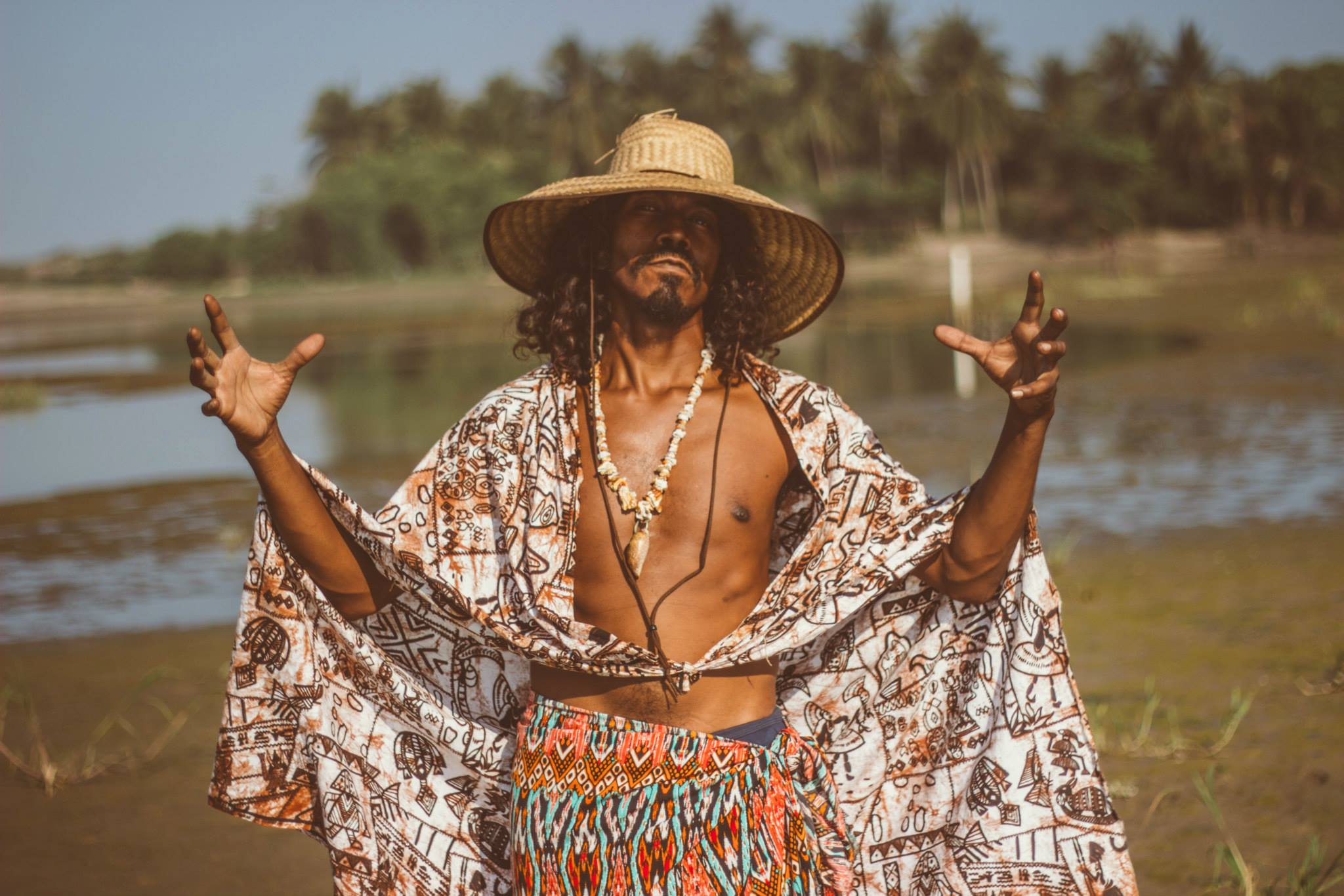 Youalli G con sombrero de palma y manta estampada frente al manglar. Foto de Evany Arzeta